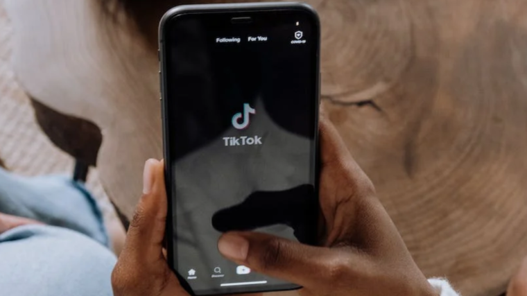 Person holding phone with TikTok